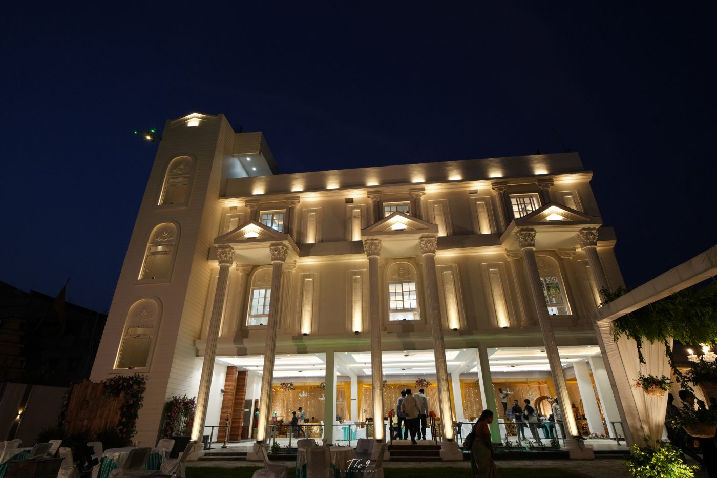 Full view of the Aarambh Banquet façade with white columns against a deep night sky