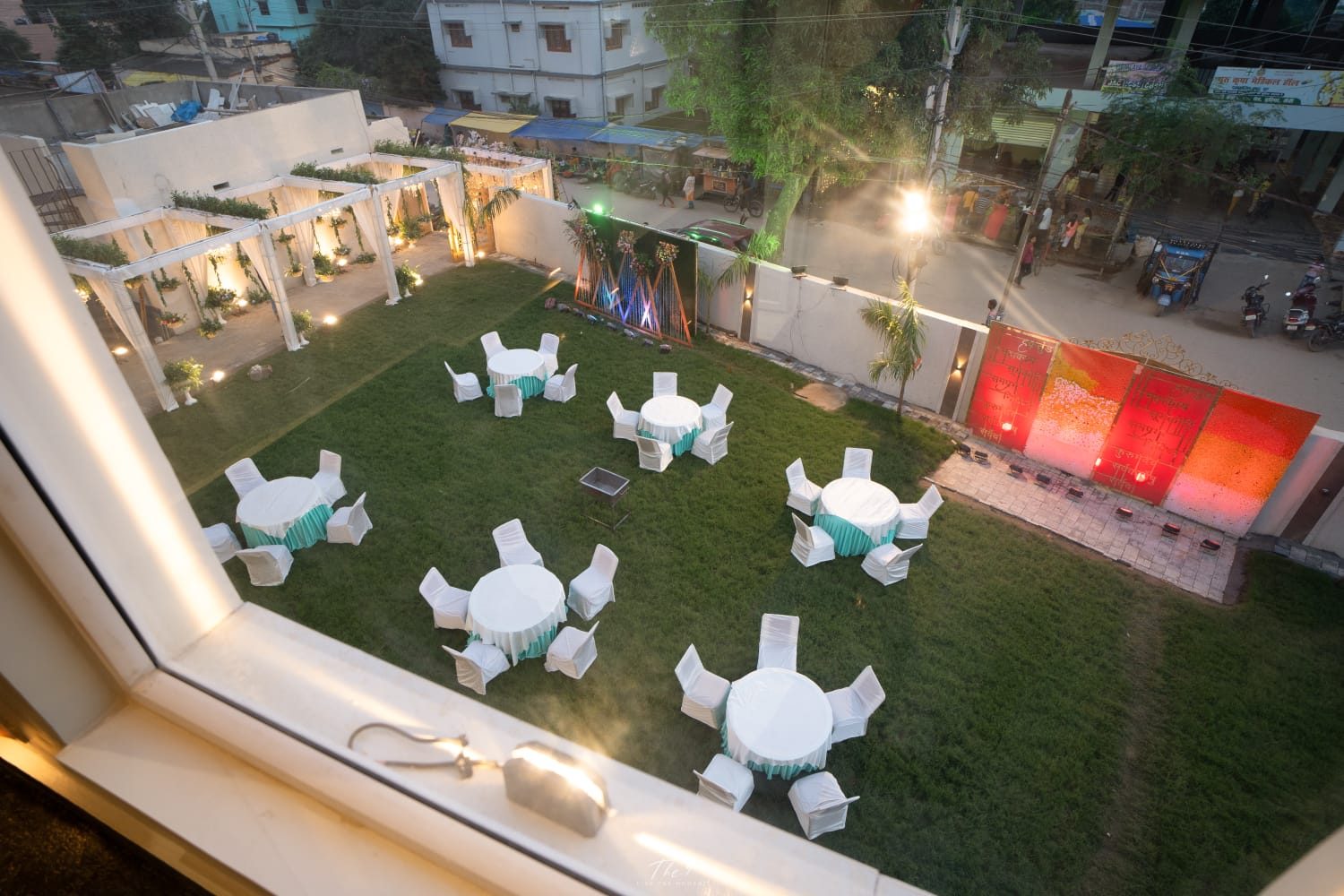 Aerial view of the garden lawn with round dining tables at dusk