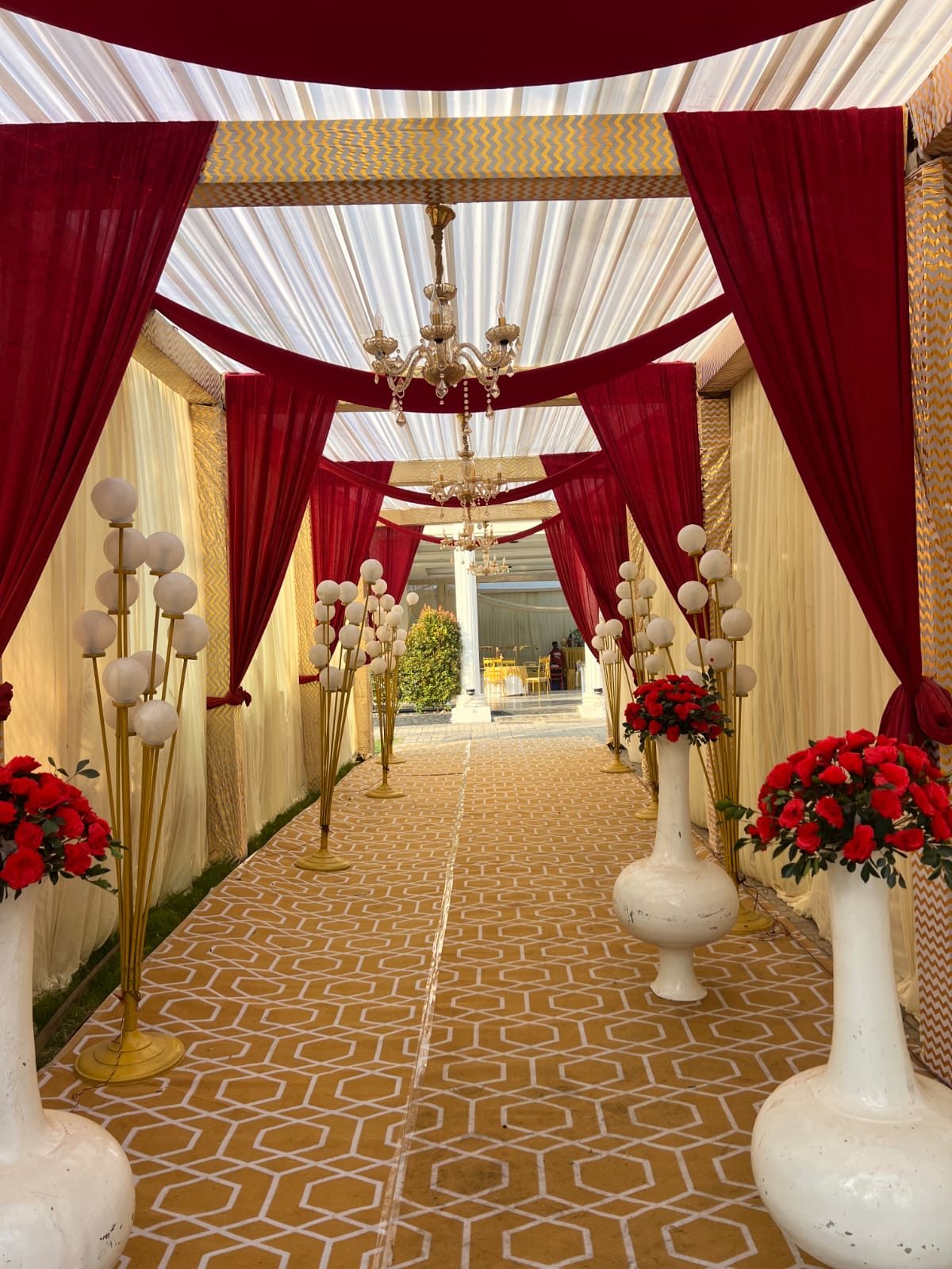 Red and white draped reception aisle under a chandelier